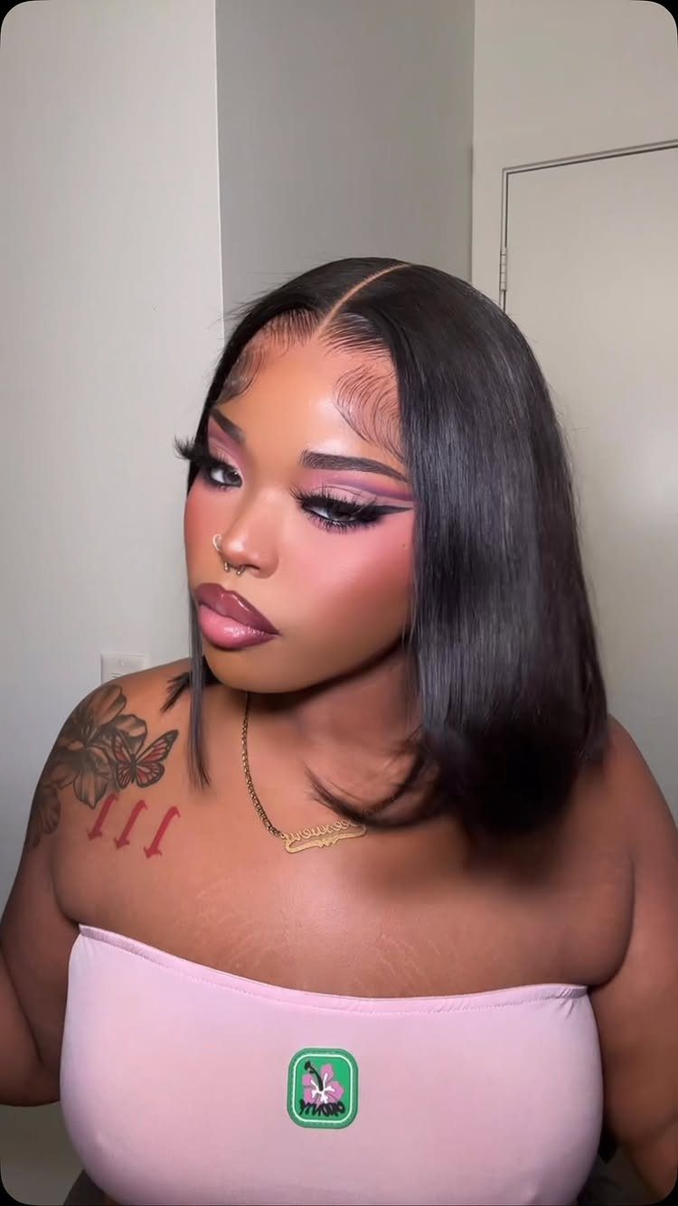 22 Hairstyles for Real Hair, from Bantu Knots to Bobs 18 Woman with a sleek black bob hairstyle, dramatic makeup, and a pink top.