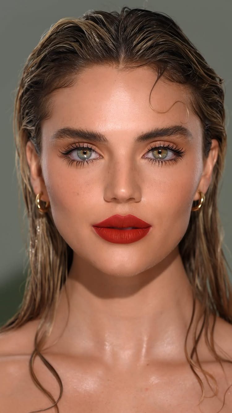 22 Hairstyles for Real Hair, from Bantu Knots to Bobs 22 Woman with wet-look slicked-back brown hair and bold red lipstick posing for portrait.