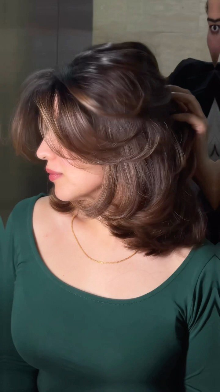 22 Hairstyles for Real Hair, from Bantu Knots to Bobs 19 Woman with voluminous brown layered hair being styled in a professional blowout.