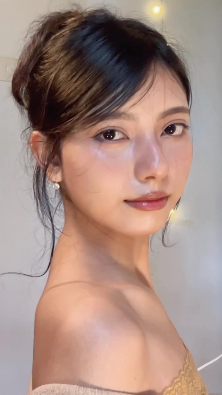 6 Hairstyles to Hide Bangs: Easy Ideas for Every Length 3 Woman with dark hair in an updo and bangs swept to the side.