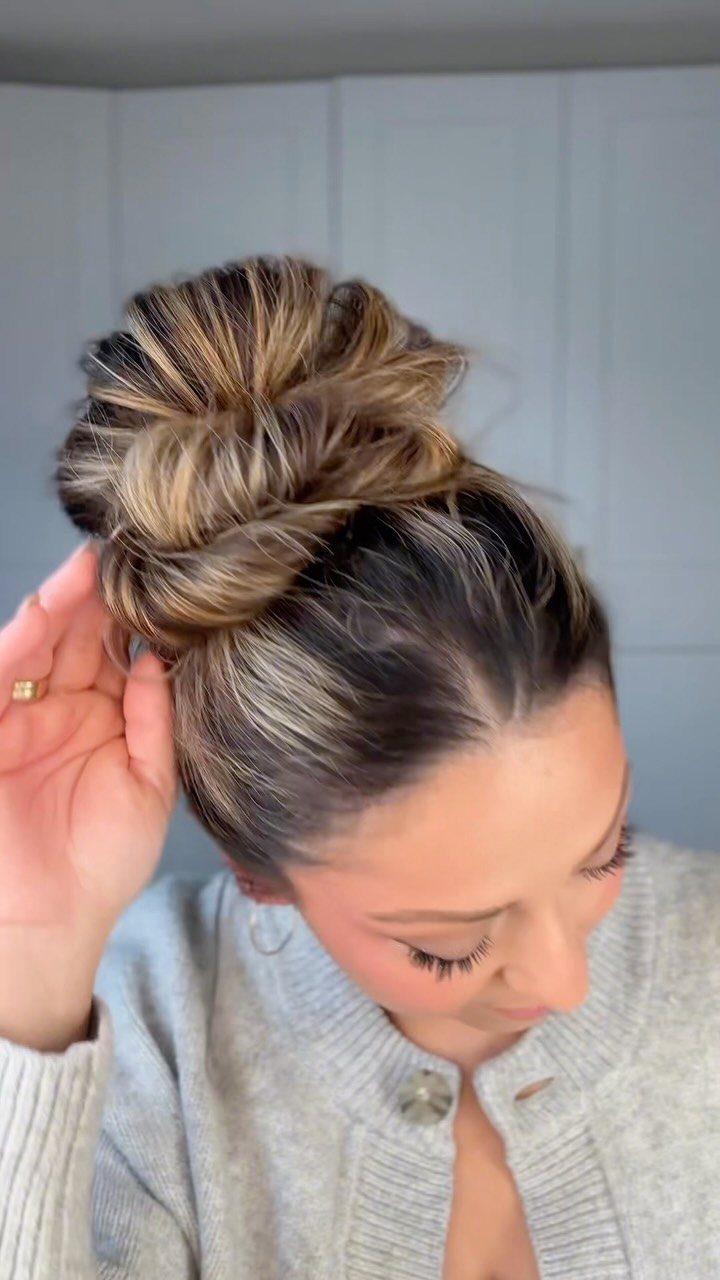6 Hairstyles to Hide Bangs: Easy Ideas for Every Length 4 Woman with highlighted hair styled in a high messy top knot bun.