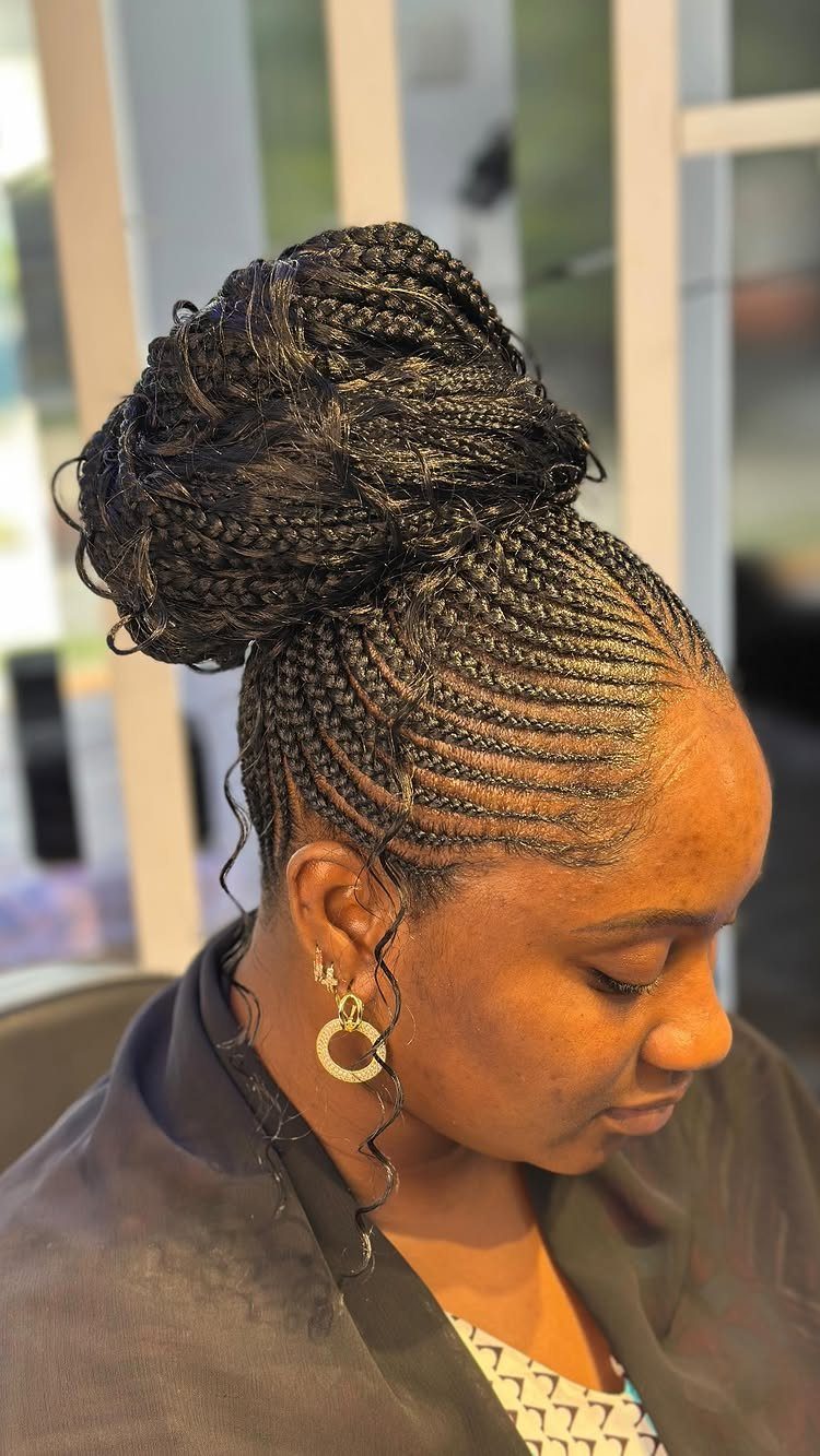 Woman with cornrows styled into a large braided bun on top of her head