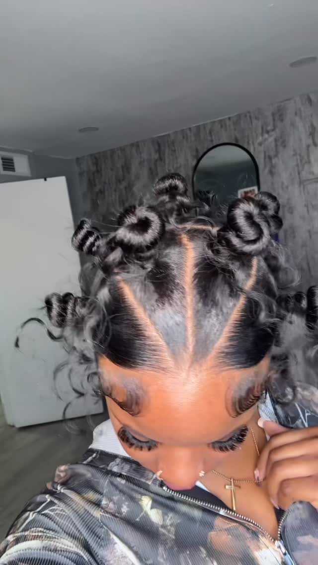 23 Hairstyles with Black Hair: Braids, Cuts, and Buns 1 Woman with black hair styled in coiled Bantu knots and sleek edges.