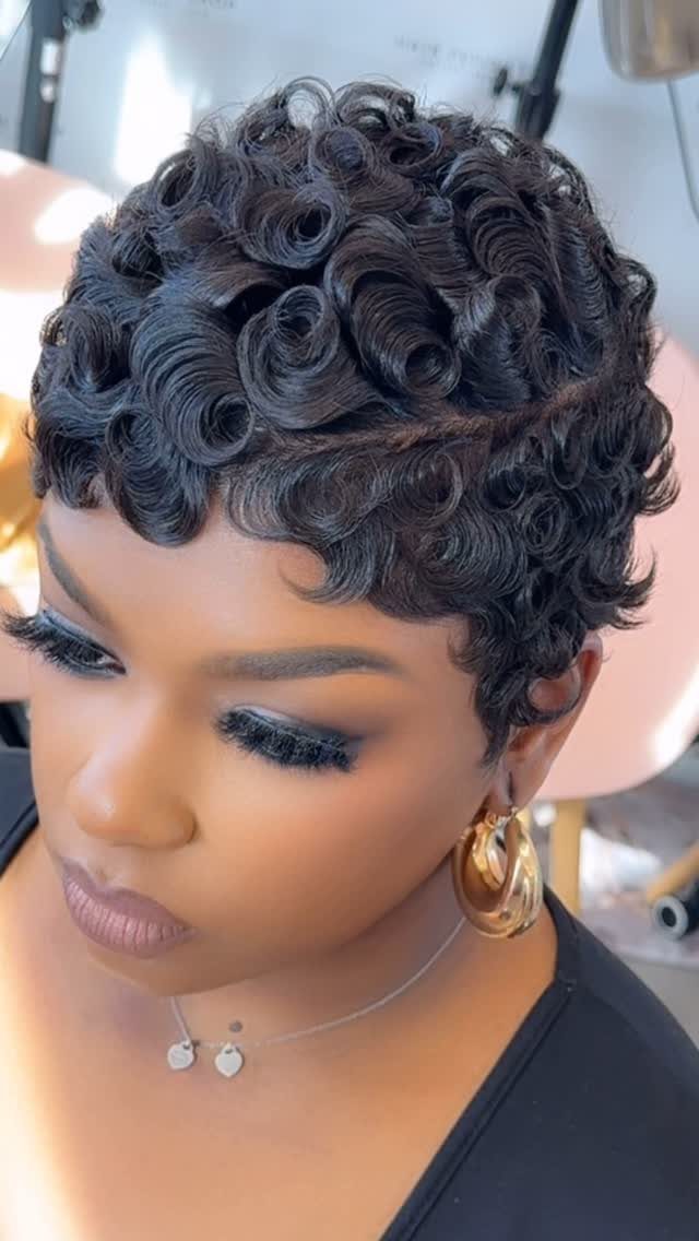 23 Hairstyles with Black Hair: Braids, Cuts, and Buns 16 Woman with a short, curly black pixie cut and gold hoop earrings.