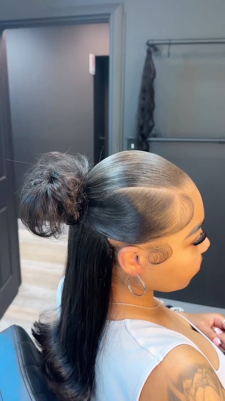 23 Hairstyles with Black Hair: Braids, Cuts, and Buns 7 Woman with black hair styled in a high bun and flowing half-down length.
