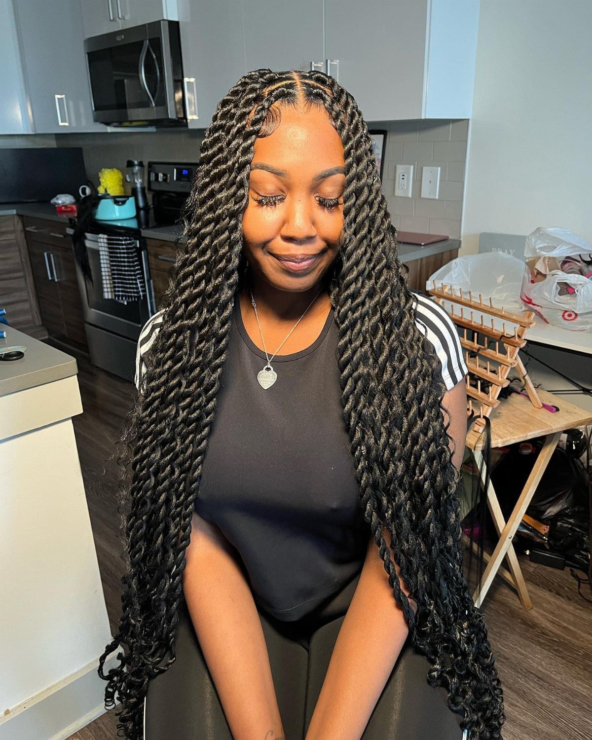 23 Hairstyles with Black Hair: Braids, Cuts, and Buns 13 Woman with long, thick black jumbo twists wearing a black t-shirt and necklace.