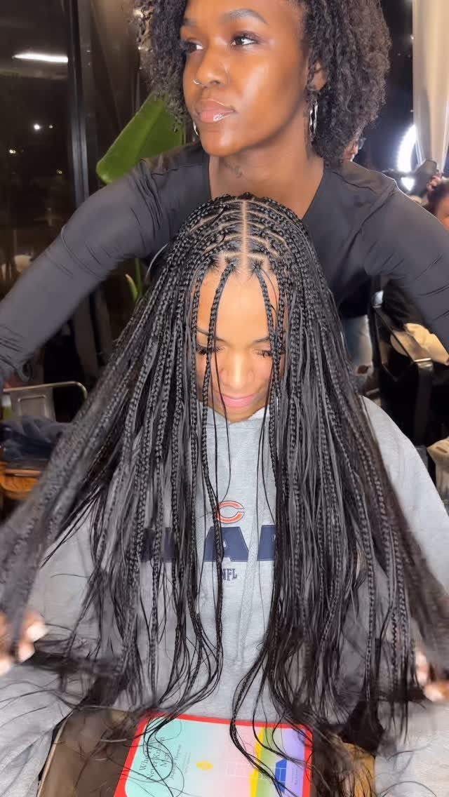 Healthy Hair Styles: 17 Protective Ideas for Natural Hair 8 Woman with long black knotless braids being styled by another woman indoors.