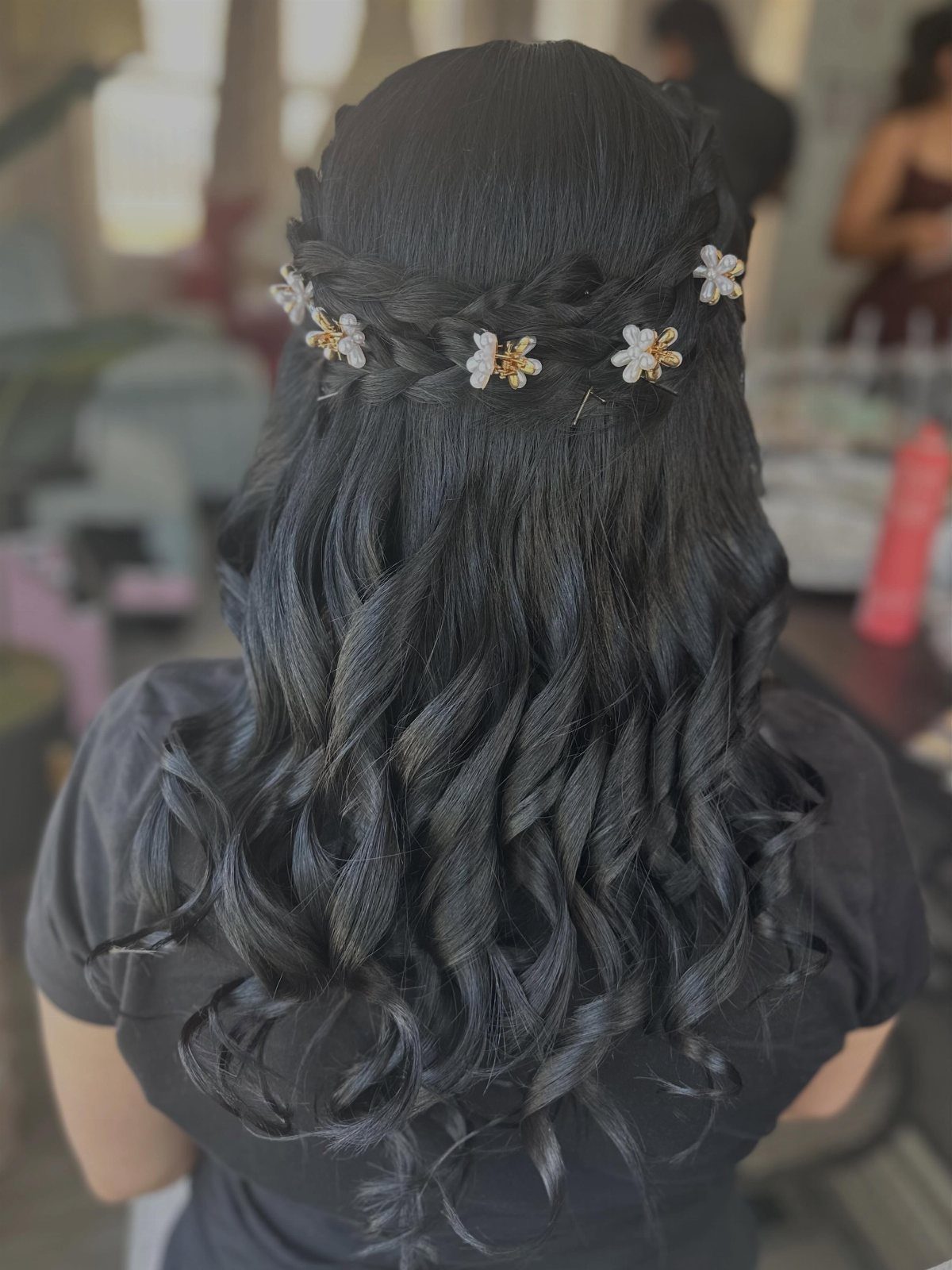 16 Homecoming Hair Curly Ideas: Buns, Braids, and Puffs 2 Dark curly hair styled in a braided crown with small floral hair accessories.