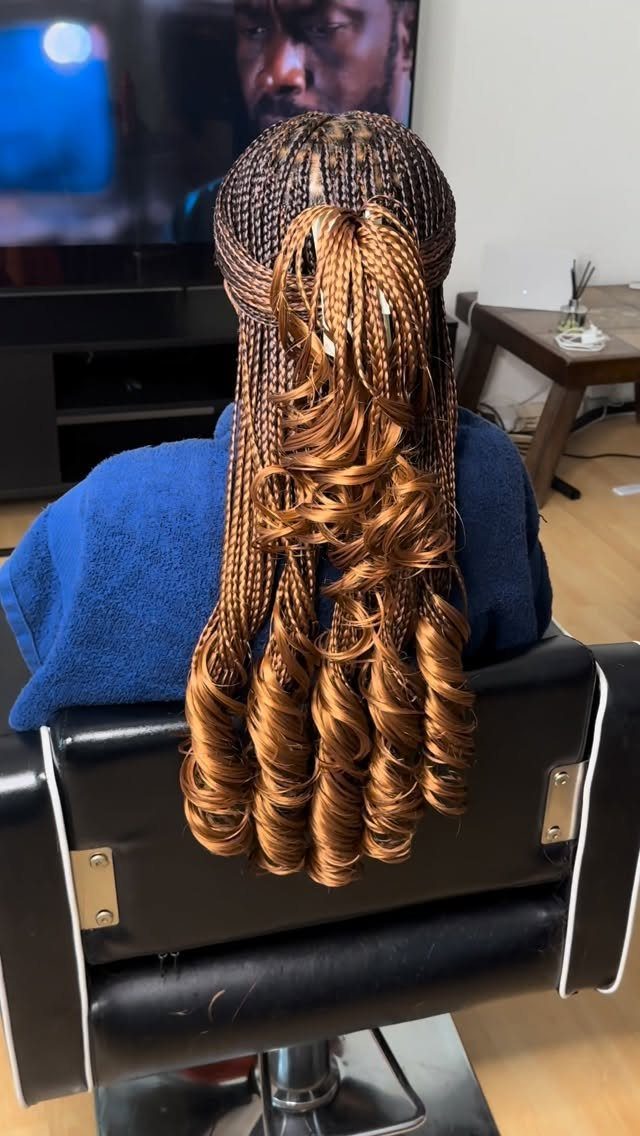 16 Homecoming Hair Curly Ideas: Buns, Braids, and Puffs 13 Brown braided hair transitioning into long, glossy spiral curls on a person's back.
