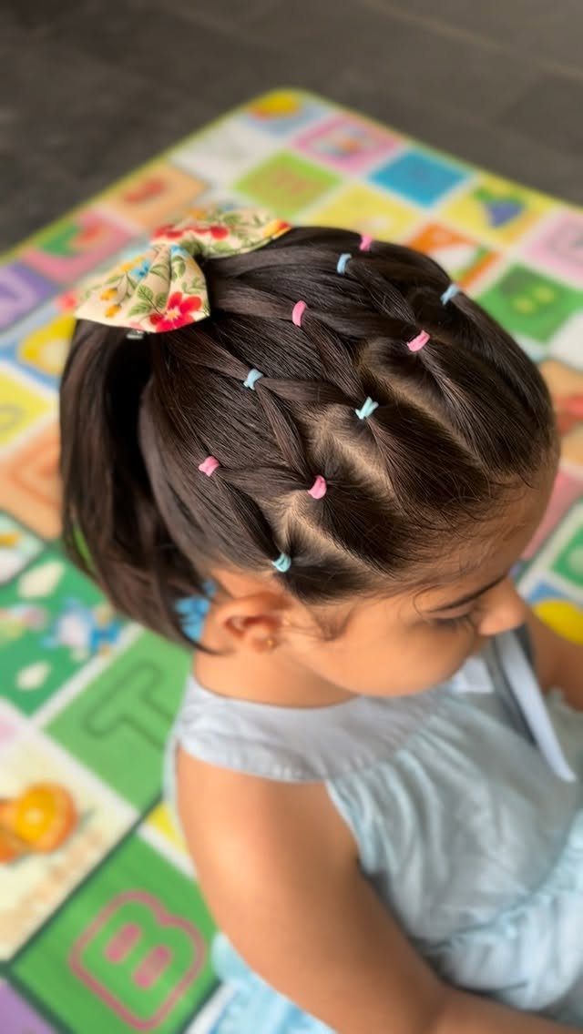 10 Little Rubber Bands for Hairstyles Kids Love 6 Young girl with dark hair styled using colorful small rubber bands and a bow