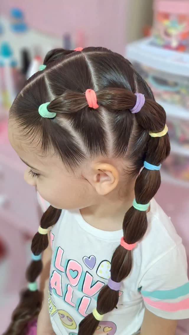 10 Little Rubber Bands for Hairstyles Kids Love 2 Young girl with brown hair in pigtail braids secured by colorful rubber bands.