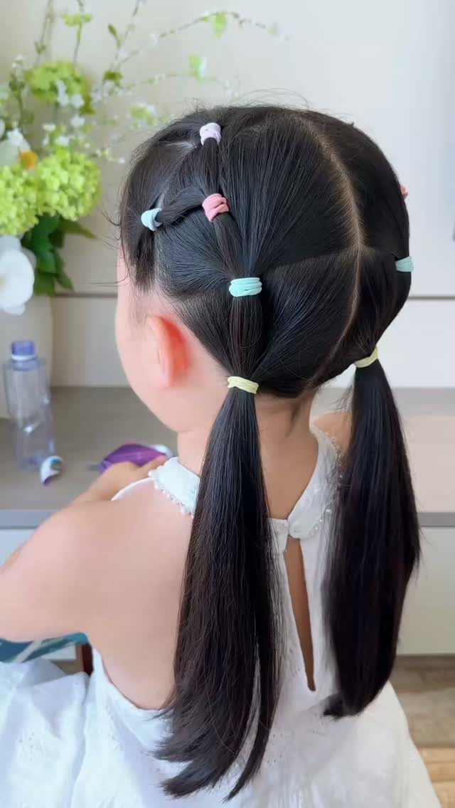 10 Little Rubber Bands for Hairstyles Kids Love 7 Young girl with black hair styled in sections with colorful rubber bands