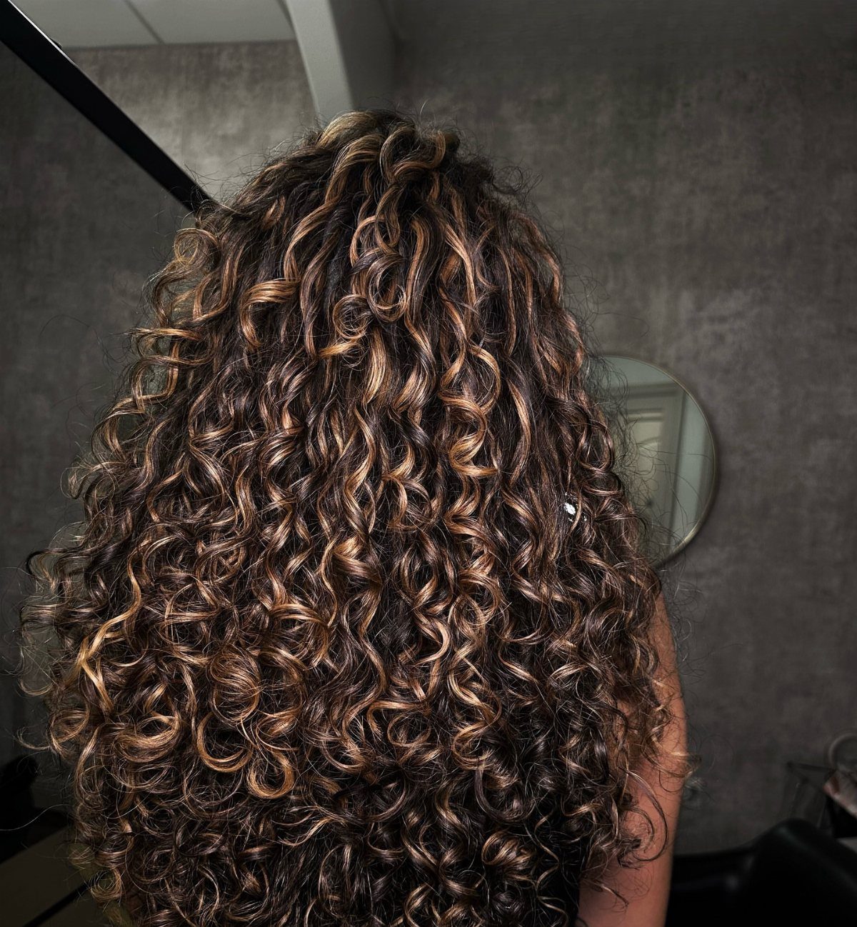 Long 3c Curly Hair Looks, Color and Updos: 15 Picks 4 Long 3c curly hair with golden blonde highlights seen from the back.