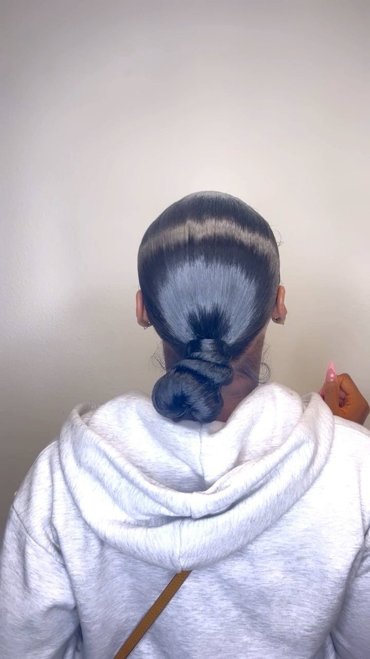 Long 3c Curly Hair Looks, Color and Updos: 15 Picks 3 Person with dark hair styled in a sleek low bun wearing a grey hoodie.