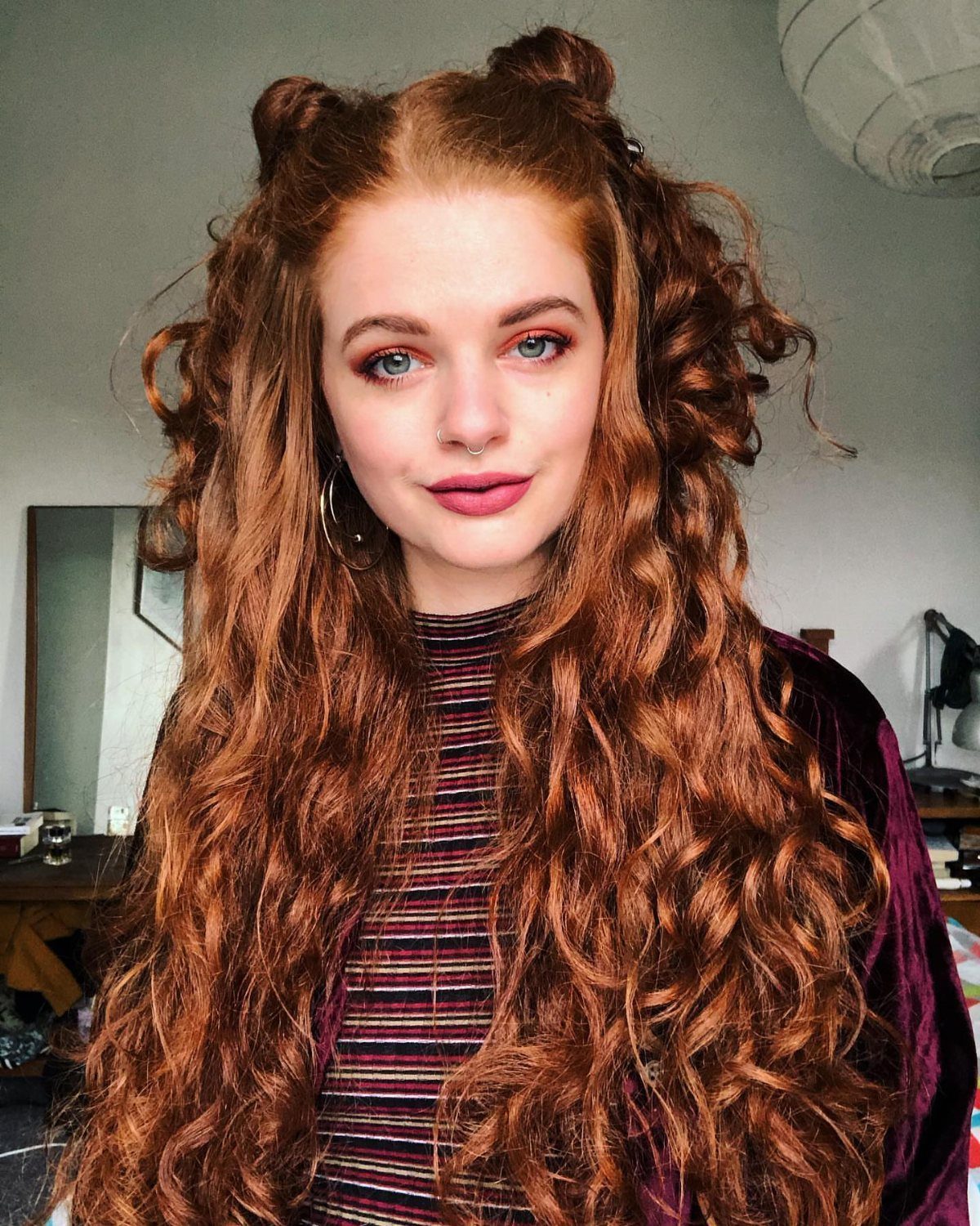 16 Long Hair Hairstyles for Party Looks You Can Copy 14 Woman with long curly red hair and two small buns on top.