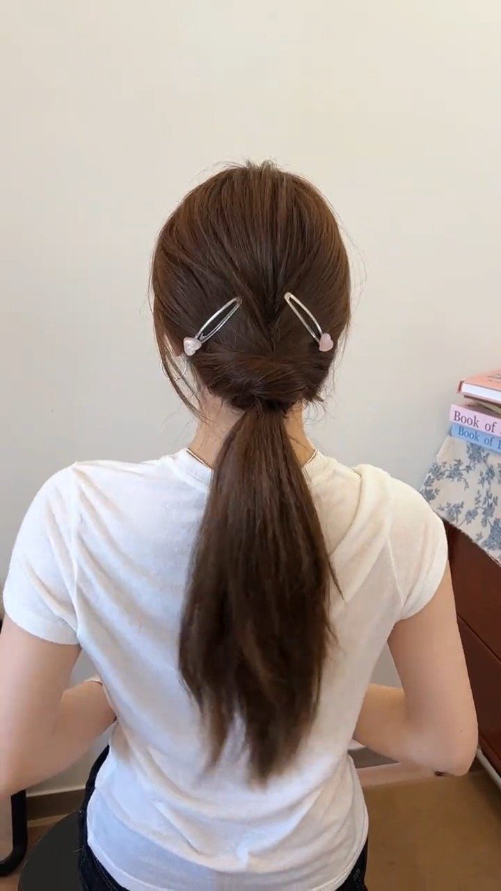 16 Long Hair Hairstyles for Party Looks You Can Copy 16 Low brown ponytail secured with two silver pearl hairpins on a woman