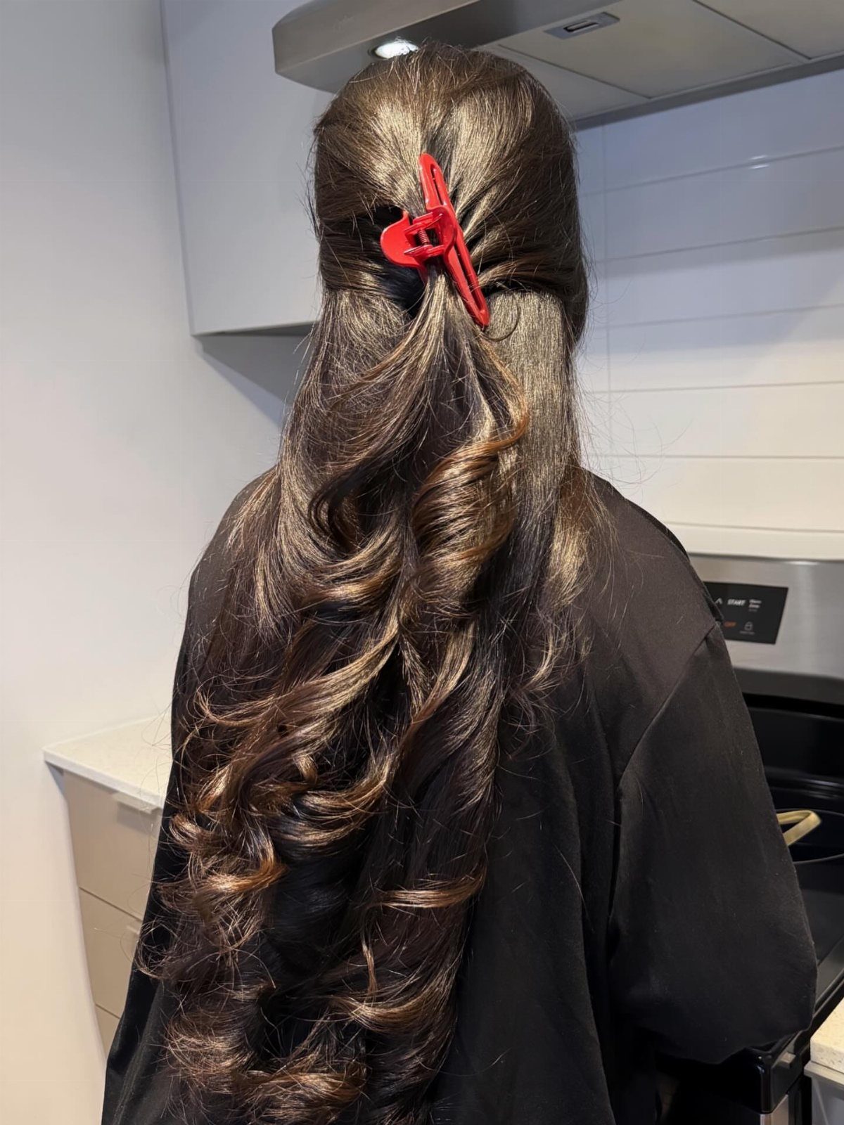 20 Long Hair Hairstyles for Work, From Buns to Braids 14 Long wavy brown hair secured at the top with a red claw clip
