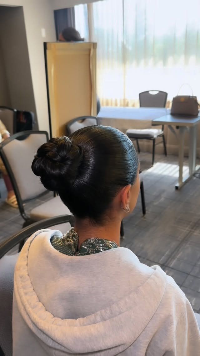 20 Long Hair Hairstyles for Work, From Buns to Braids 1 Dark hair styled in a sleek low bun from a back view