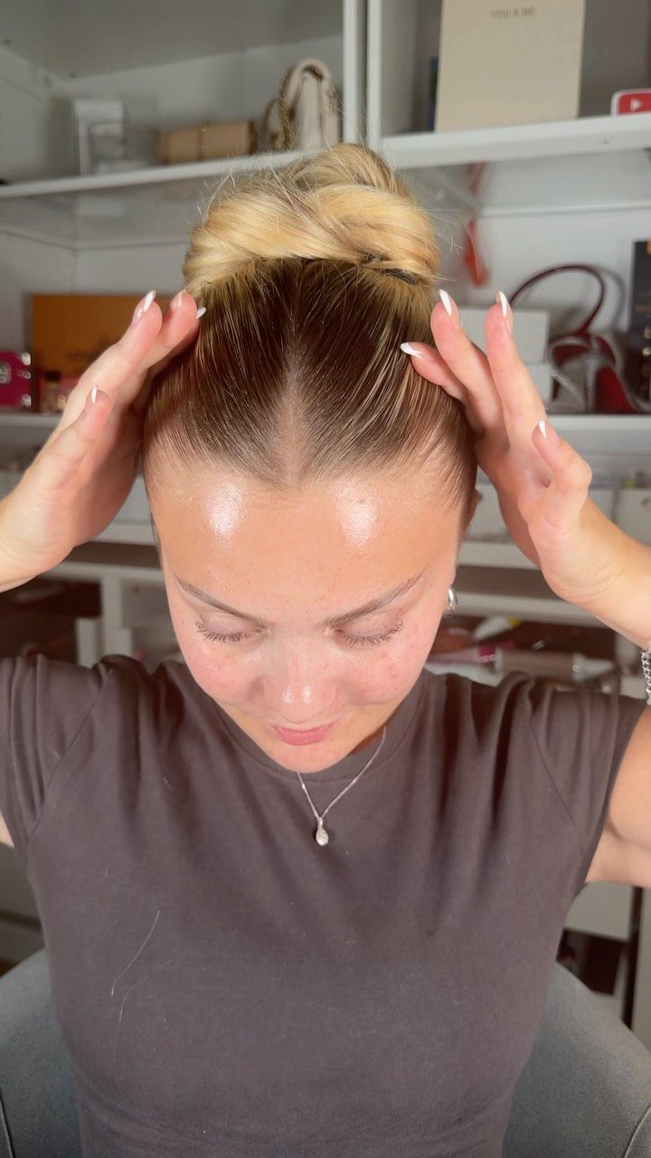 20 Long Hair Hairstyles for Work, From Buns to Braids 8 Woman with blonde hair styled in a high twisted top knot bun.