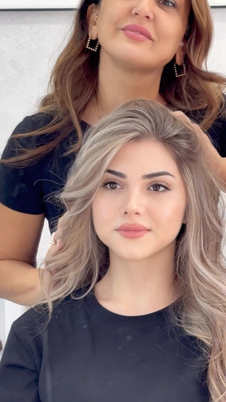 20 Long Hair Hairstyles for Work, From Buns to Braids 4 Woman with long blonde undone waves and a side part wearing black top