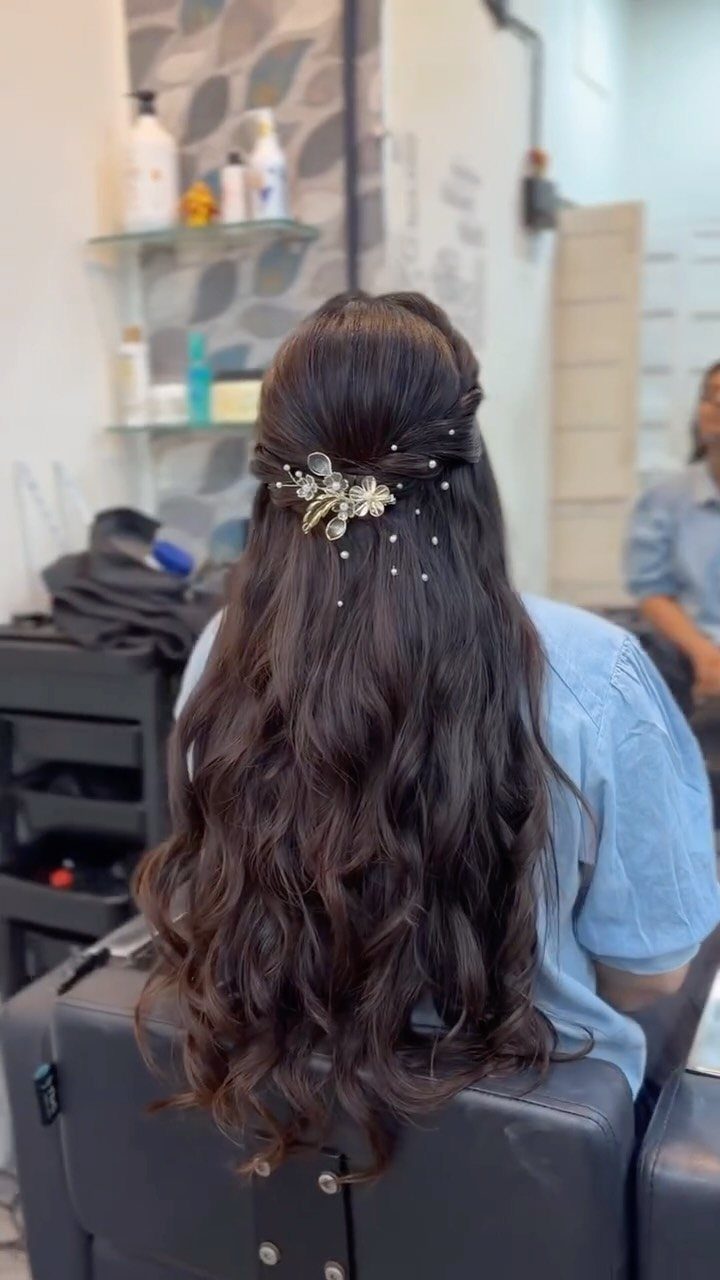Long Hair Without Layers: 9 One-Length Styles to Try 5 Long dark brown curly hair styled in a half-updo with gold floral accessory.