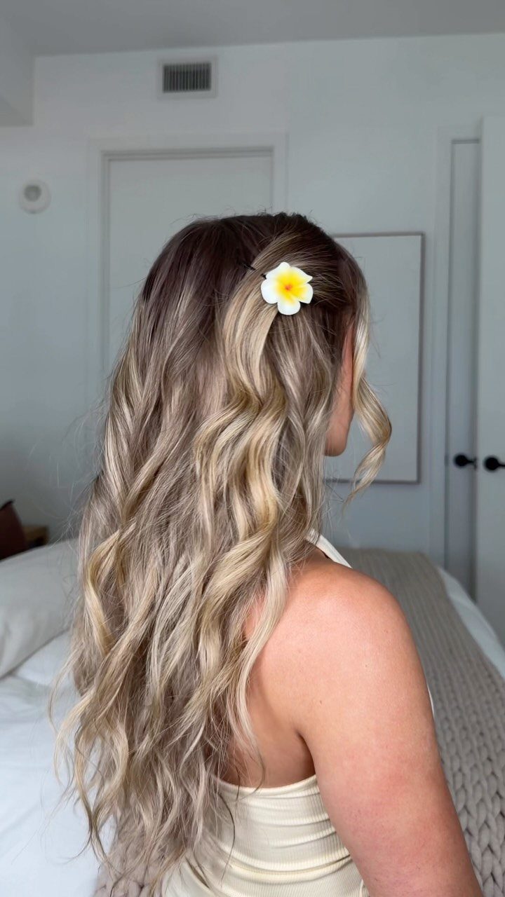 11 Long Loose Hair Ideas for Every Style and Texture 3 Long wavy blonde hair with a white flower tucked behind the ear.