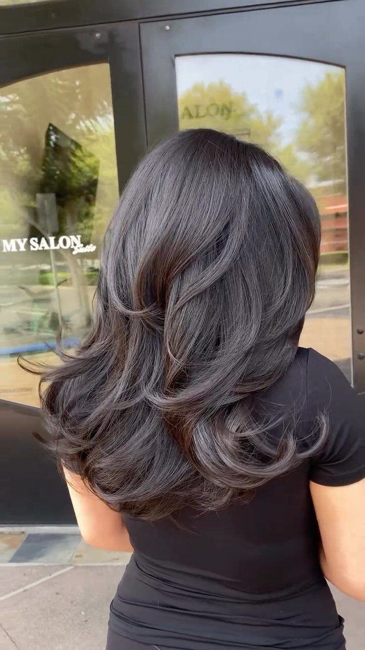 11 Medium Length Curly Hair Hairstyles for Every Look 11 Medium length dark brown hair styled in voluminous, polished curls from behind.