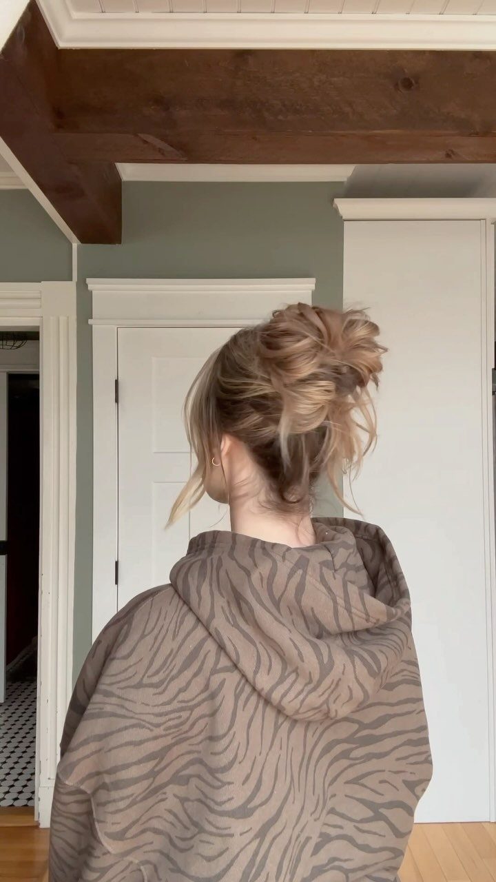 Messy Bun Outfit: 7 Ideas from Jeans to Animal Print 7 Woman with a blonde messy bun wearing a tiger-print hooded sweatshirt from behind.