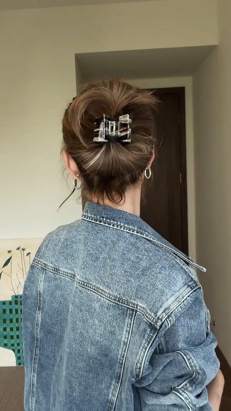 Messy Bun Outfit: 7 Ideas from Jeans to Animal Print 2 Brown hair in a messy bun with a silver claw clip and denim jacket.