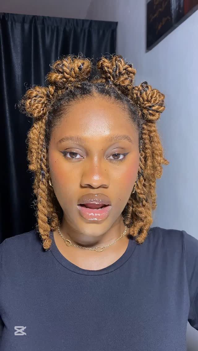 Woman with brown mini twists styled into two high buns and loose ends.