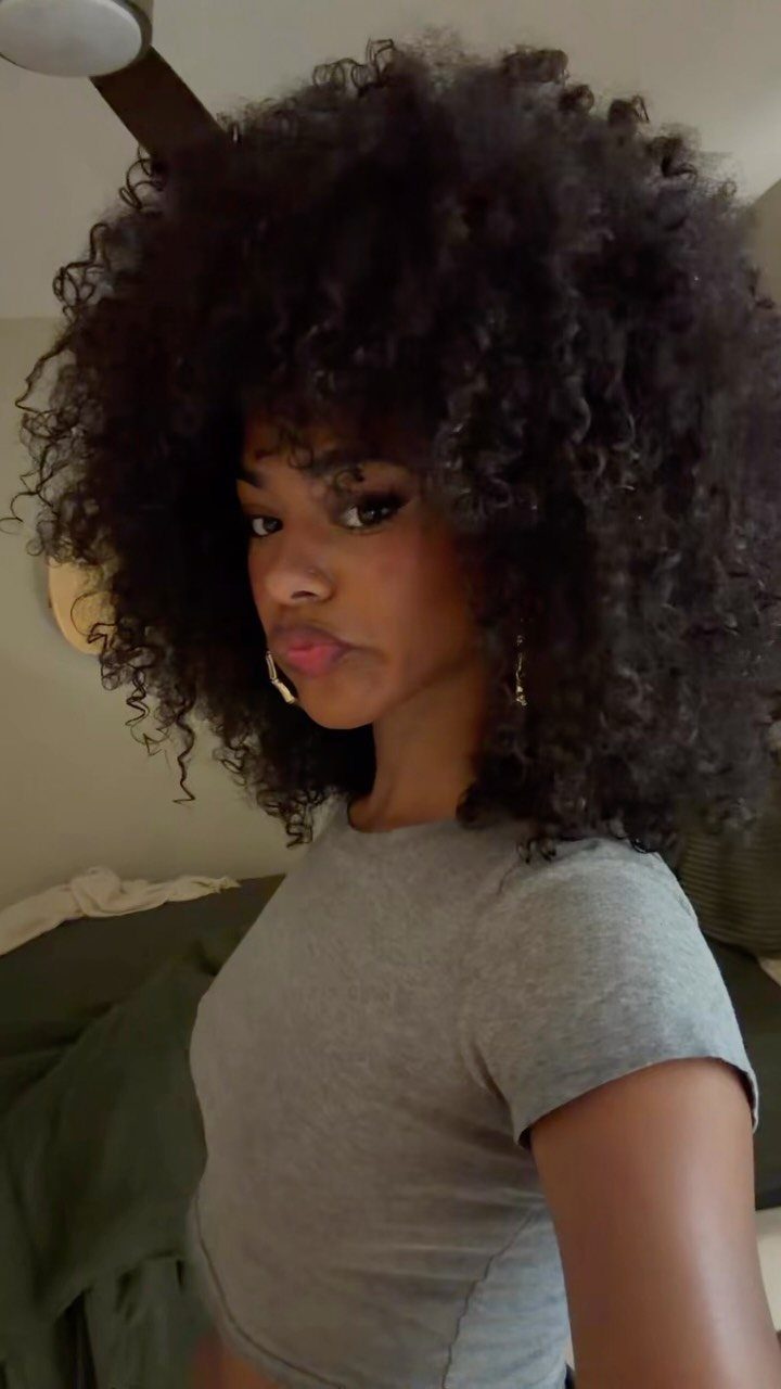 17 Natural Curly Hairstyles for Short Hair You Can Wear 15 Woman with a large, voluminous dark curly afro and gold hoop earrings.