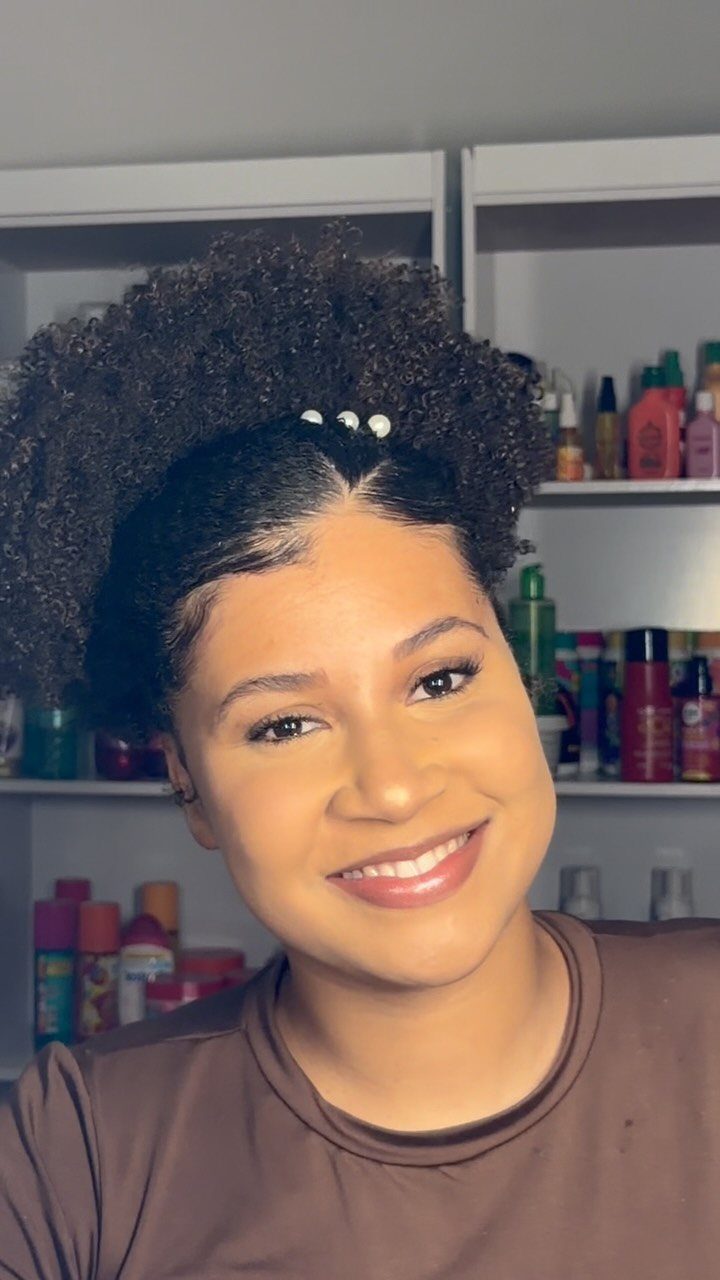 17 Natural Curly Hairstyles for Short Hair You Can Wear 6 Woman with slicked sides and a voluminous curly afro puff on top.