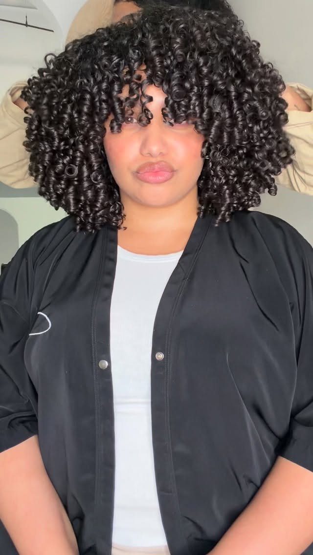 17 Natural Curly Hairstyles for Short Hair You Can Wear 7 Woman with tight, defined dark ringlets framing her face and shoulders.
