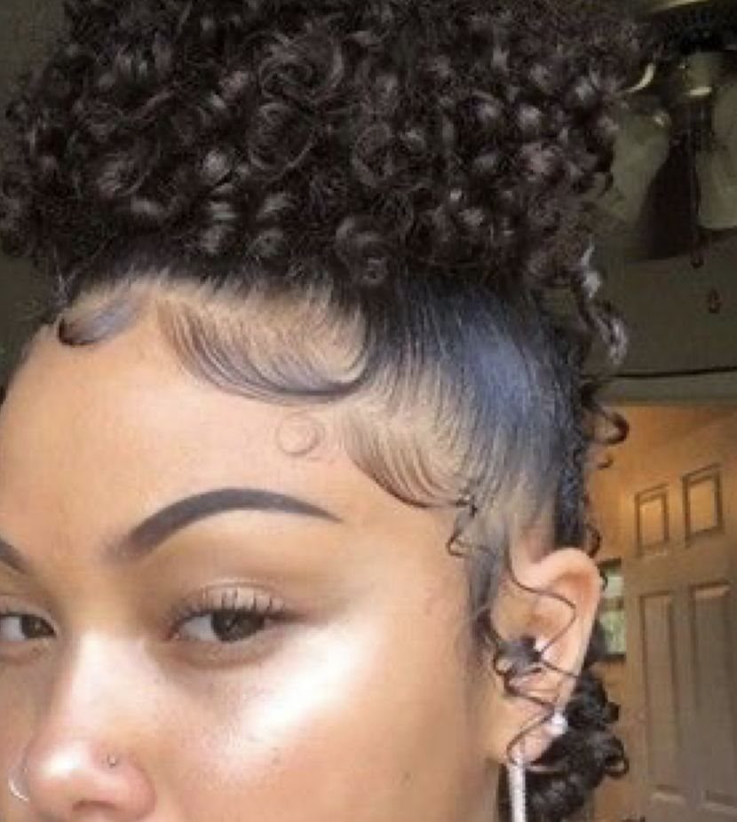 Person with a curly high puff hairstyle and smooth, styled laid edges.