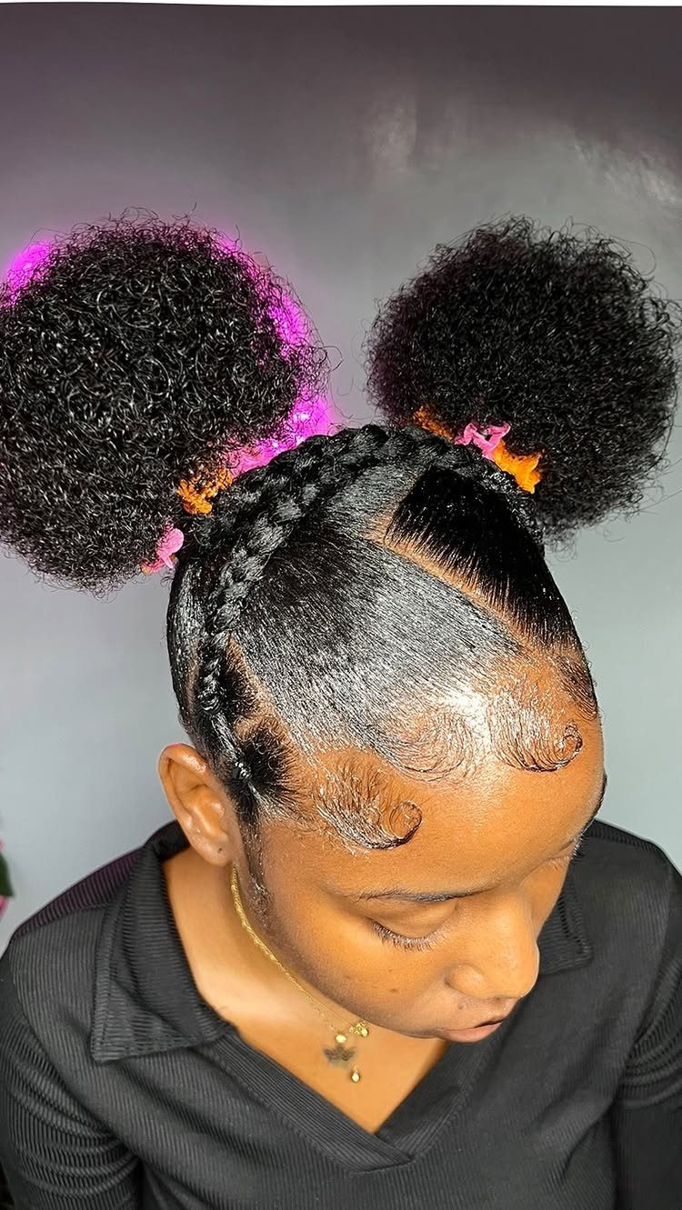 Person with two large afro puffs, braided crown, and styled edges.