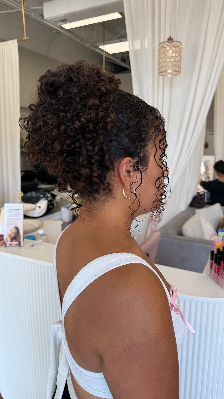Naturally Curly Prom Hairstyles: 4 Ideas to Try 2 Woman with dark curly hair styled in an elegant high updo and white dress.