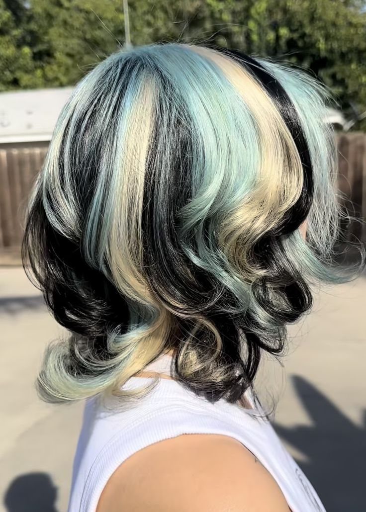 Neapolitan Hair Blue: 5 Ideas for Streaks and Peekaboos 2 Curly shoulder-length hair with thick vertical streaks of black, blue, and blonde.