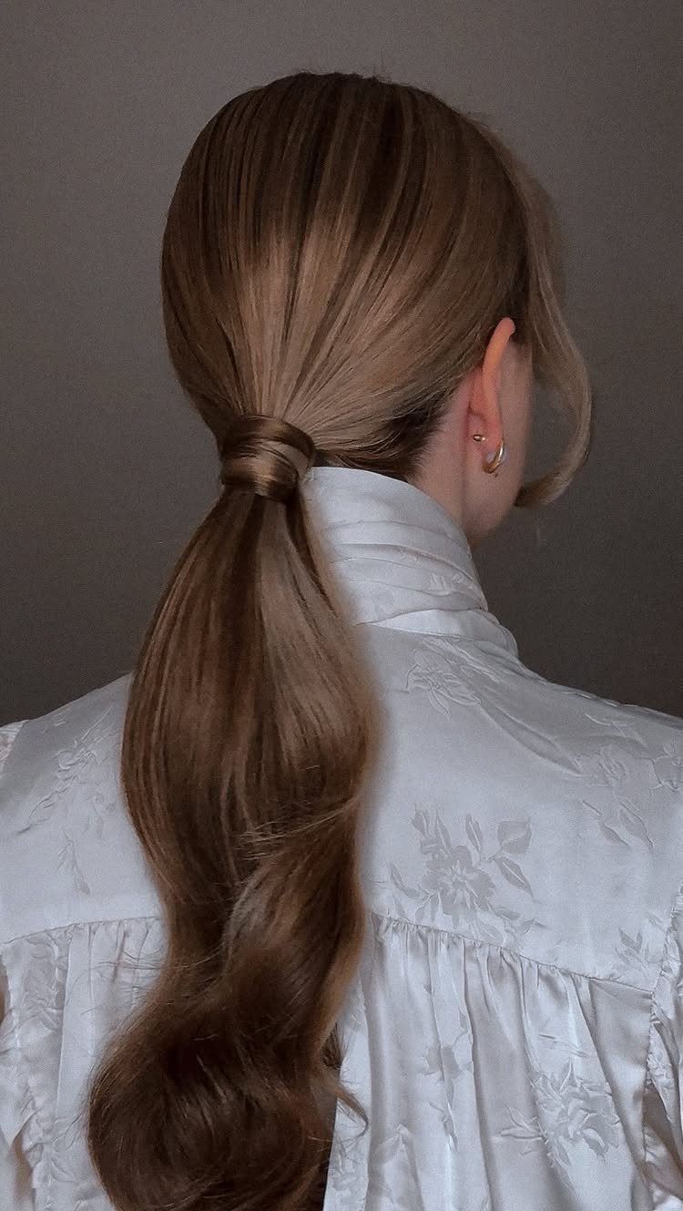 Blonde low ponytail with a strand of hair wrapped to hide the tie
