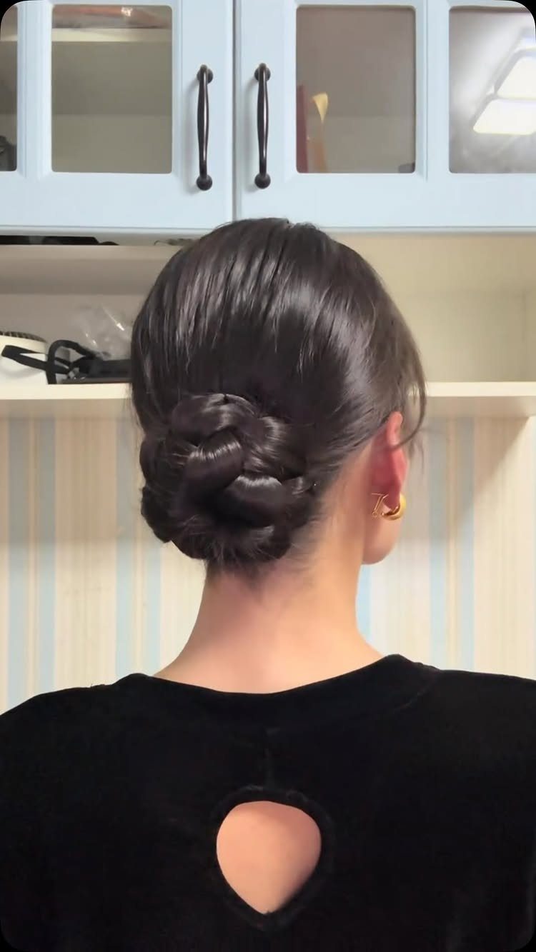 Dark brown hair styled in a twisted low bun at the nape.