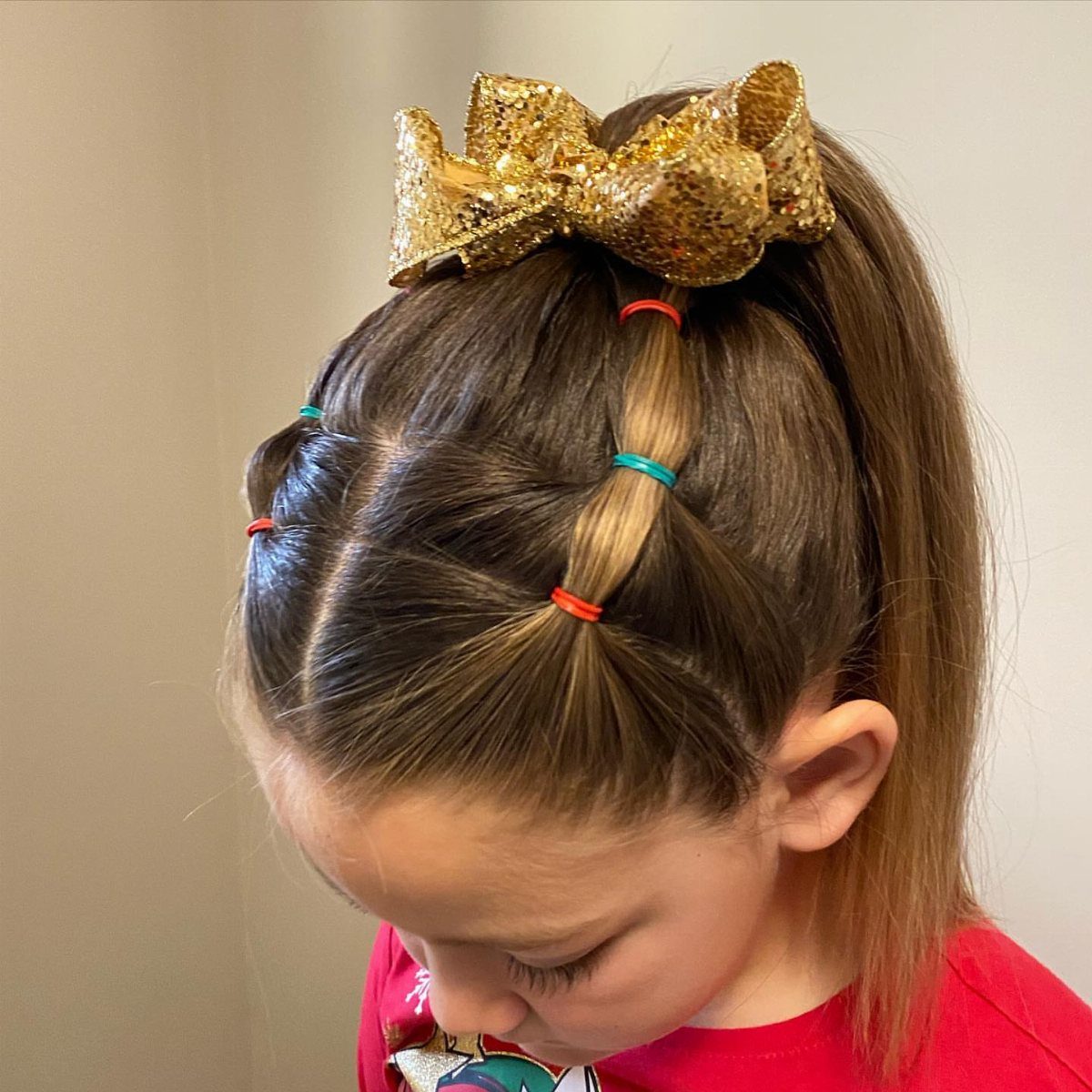 11 Picture Day Hair Ideas for Kids, from Braids to Bows 10 Girl with a high ponytail, gold glitter bow, and colorful bubble hair ties.