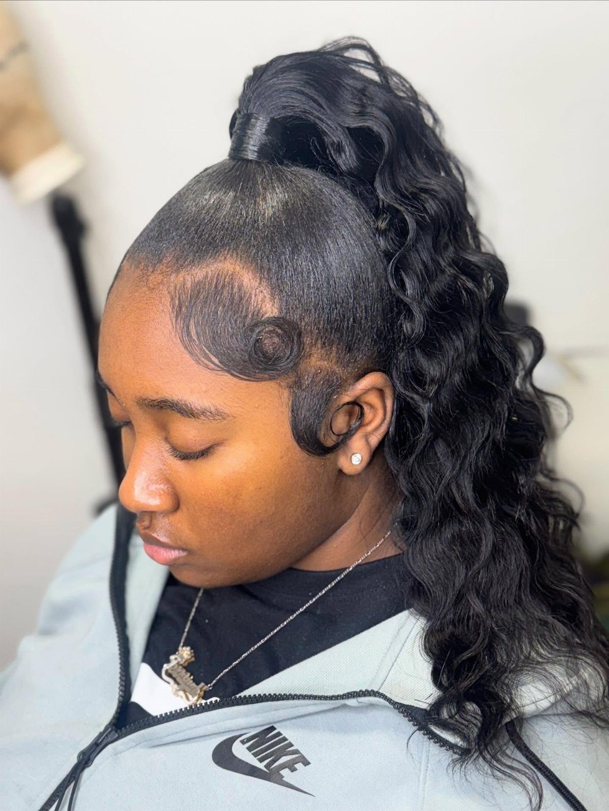 11 Picture Day Hair Ideas for Kids, from Braids to Bows 9 Young woman with a high curly ponytail and styled edges wearing a grey jacket