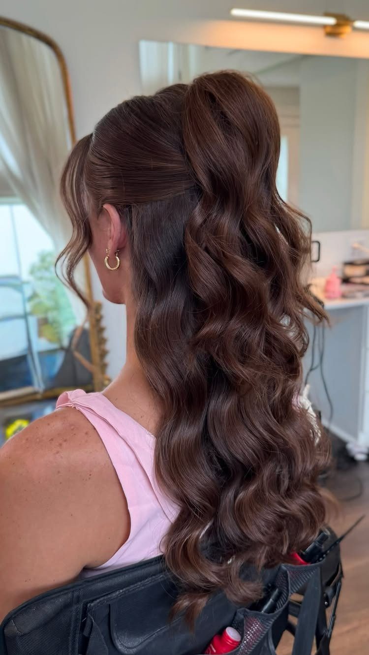 Pin Up Curls Hairstyles to Try: 6 Retro Ideas 3 Woman with brown hair in a high half-up ponytail with voluminous curls.