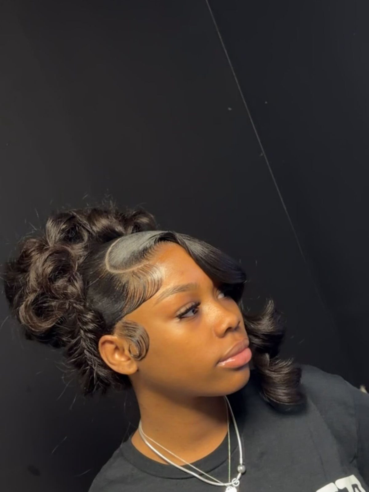 Pin Up Curls Hairstyles to Try: 6 Retro Ideas 2 Woman with dark hair styled in voluminous retro curls and a structured updo.