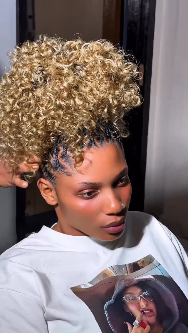 Puff Ball Hairstyle Ideas: 5 Styles With Afro Puffs and Bows 2 Woman with a blonde curly hair puff and braided sides wearing a white shirt