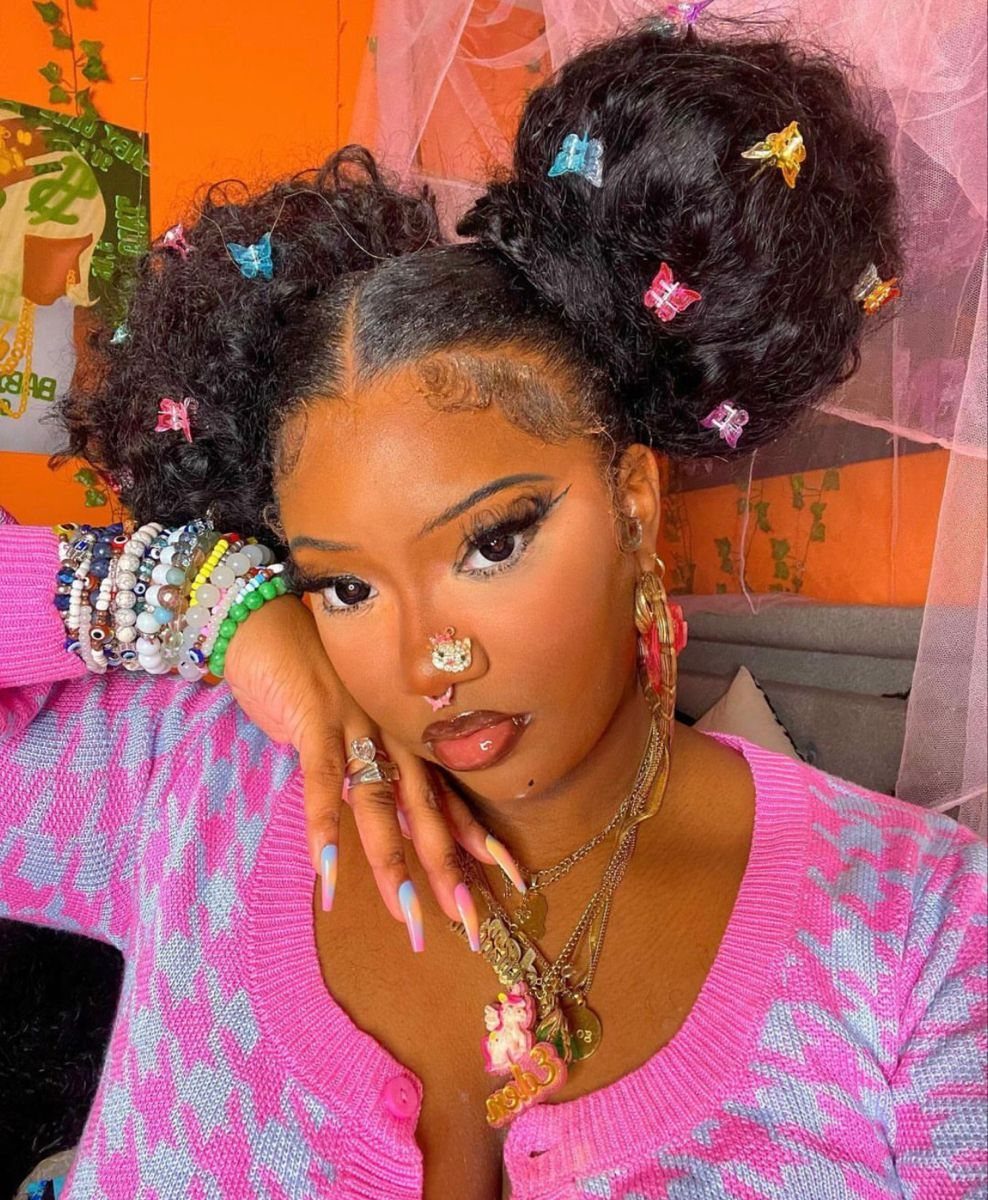 Puff Ball Hairstyle Ideas: 5 Styles With Afro Puffs and Bows 3 Woman with two high hair puffs decorated with colorful butterfly clips and jewelry.