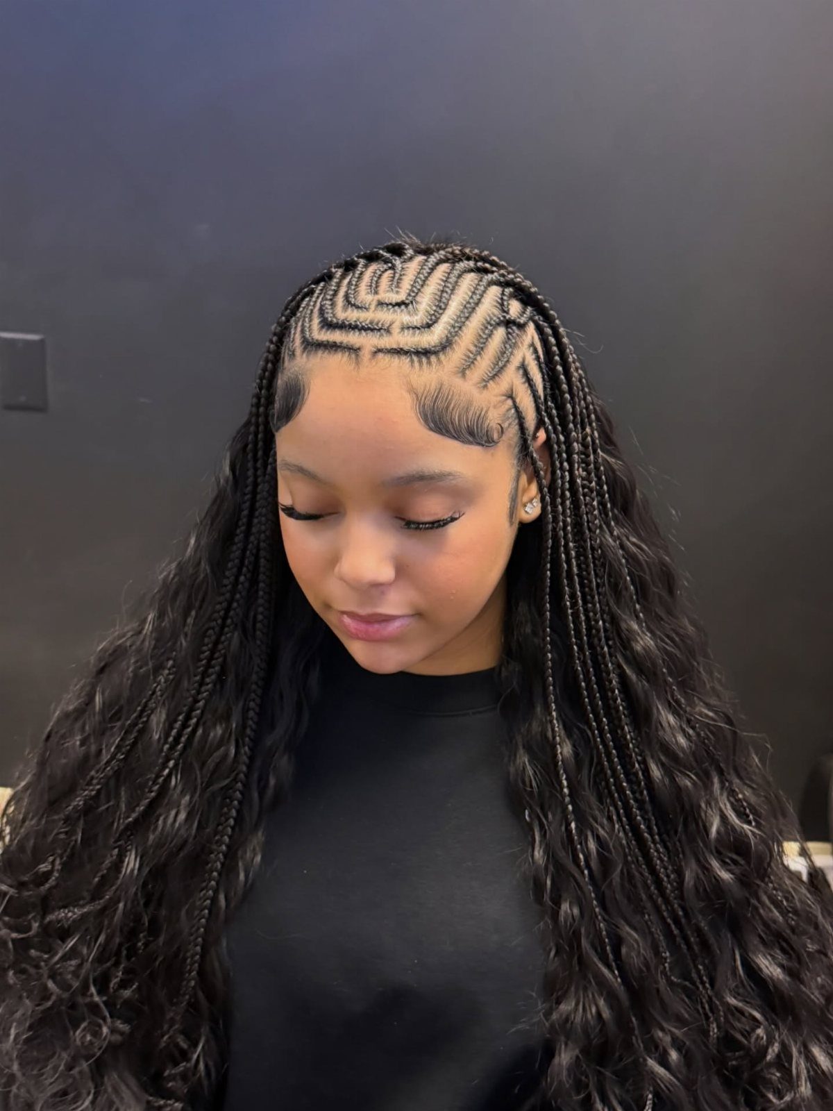 Quick Weave Styles with Braids: 18 Cornrow and Updo Ideas 18 Woman with geometric cornrow braids and long, dark wavy hair extensions.