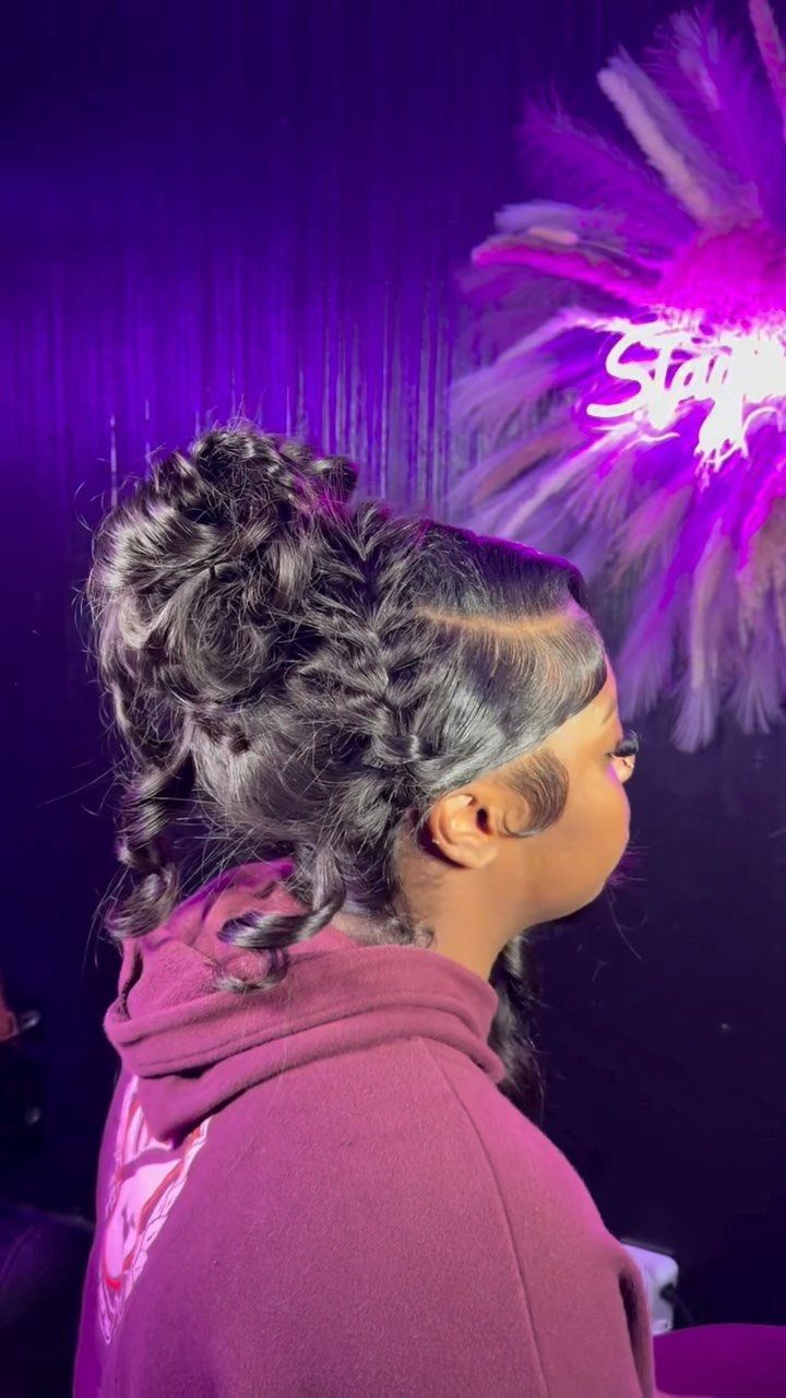 Quick Weave Styles with Braids: 18 Cornrow and Updo Ideas 3 Woman with a low braided updo weave and curly knotted bun in purple lighting