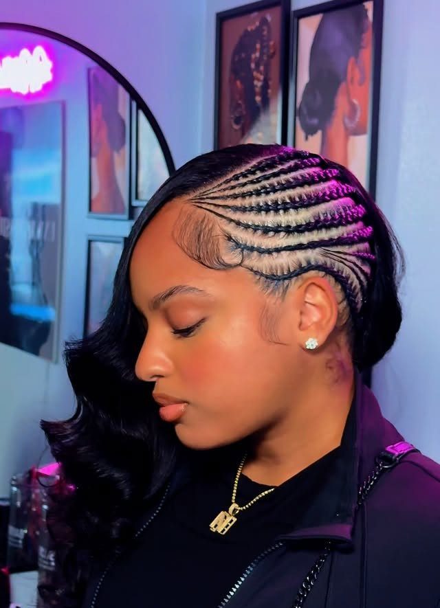 Quick Weave Styles with Braids: 18 Cornrow and Updo Ideas 1 Woman with side cornrows and long curly black hair wearing a black jacket.