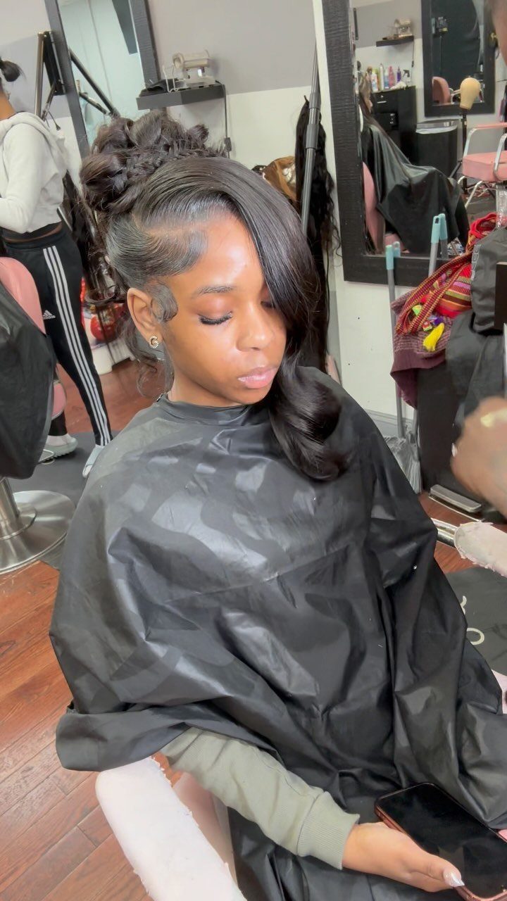 Quick Weave Styles with Braids: 18 Cornrow and Updo Ideas 9 Woman with a sleek side-swept fringe and a textured braided bun hairstyle.