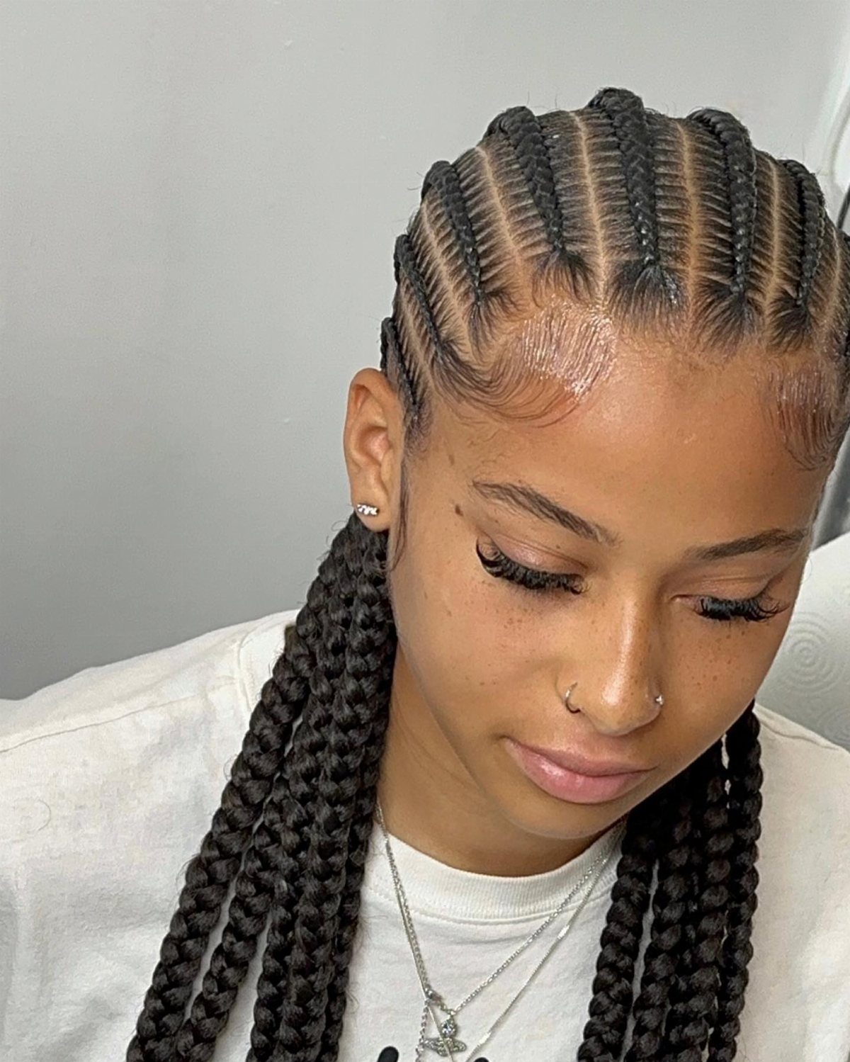 Quick Weave Styles with Braids: 18 Cornrow and Updo Ideas 8 Woman with neat straight-back stitch braids transitioning into long thick dark braids.